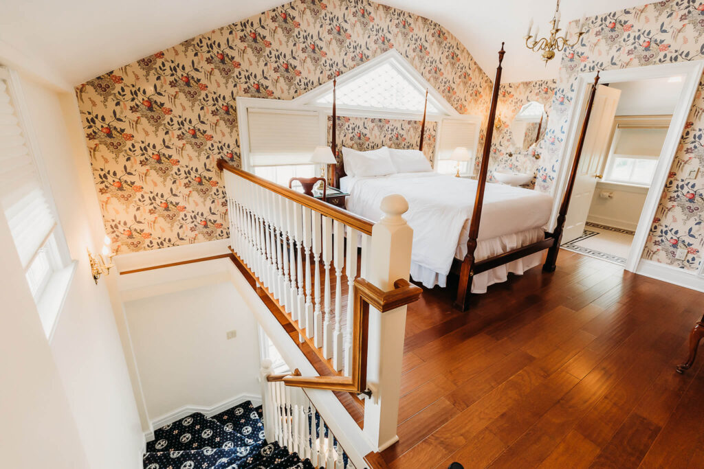 Lofted bedroom surrounded by vintage wallpaper.