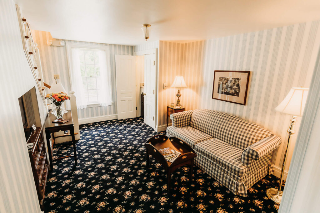 A sitting room that features a coffee table with reading materials and a TV ahead.