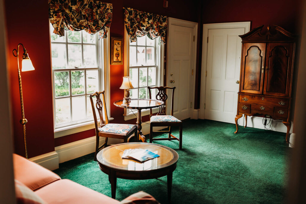 A sitting room in The Rochester Inn that has a large antique wardrobe.