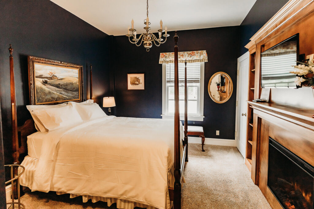 Overview of a room offered that features a large bed, a TV, and a fireplace.