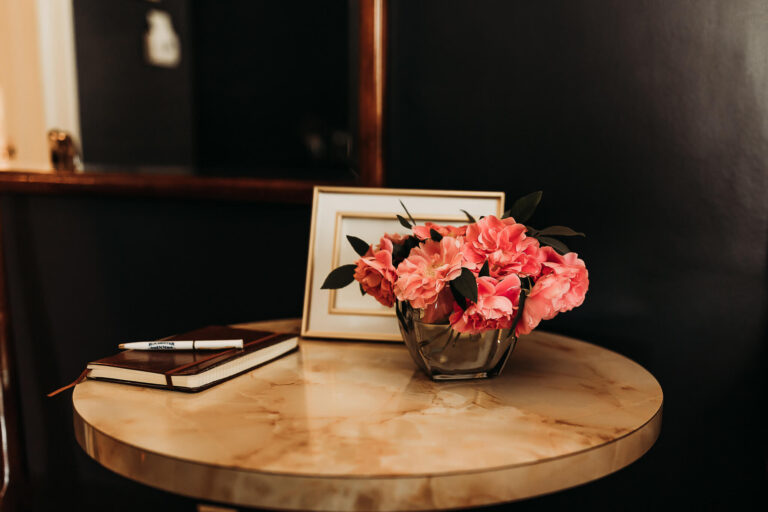 Table with flowers and a guest book on top.